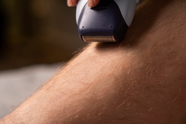 Side view woman shaving leg