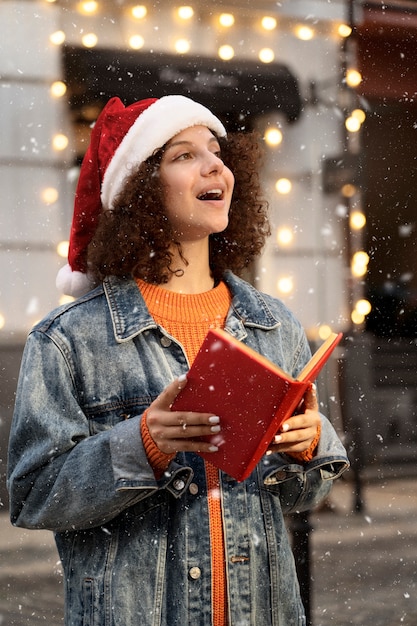 Donna di vista laterale che canta il canto di natale