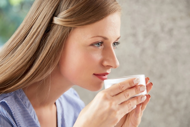 Side view of a woman sipping coffee
