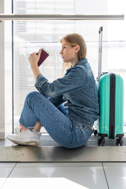 side view of woman sitting in airport