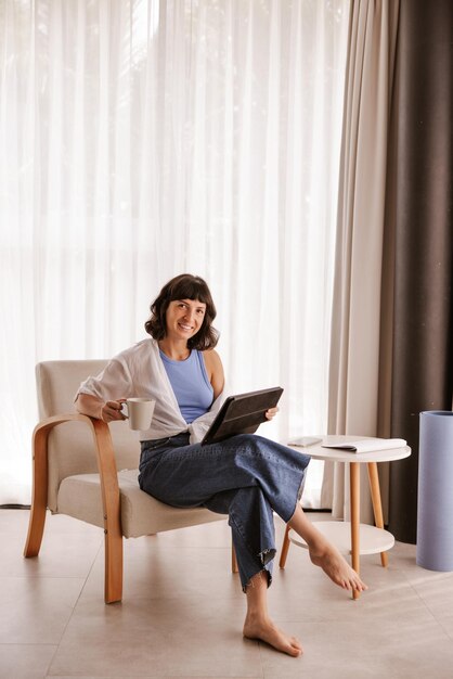 The side view of woman sitting in chair looking and smiling at camera