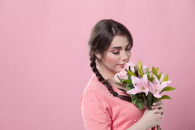 Side view of woman smelling bouquet of lilies with copy space