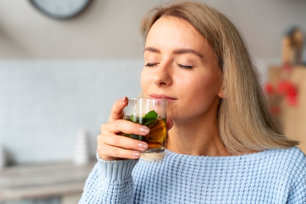 Side view woman smelling kombucha