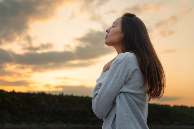 Free photo side view woman standing outdoors