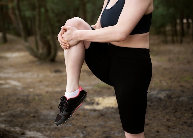 Side view woman stretching outdoors