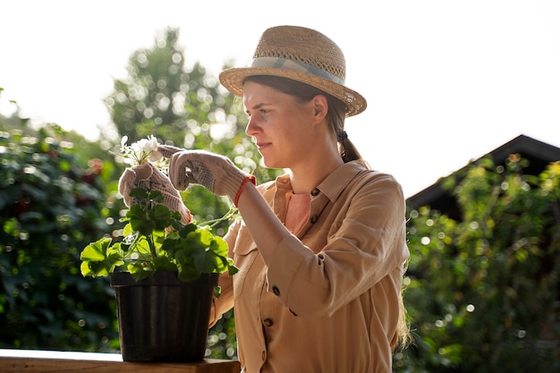 屋外で植物の世話をする女性の側面図
