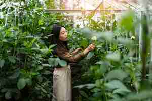 Free photo side view woman taking care of plants