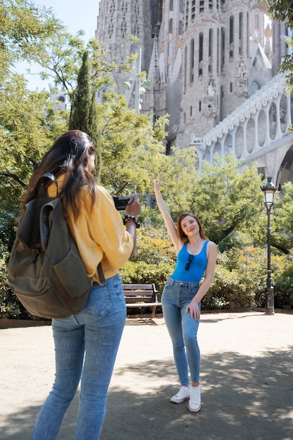 Free photo side view woman taking photos of friend