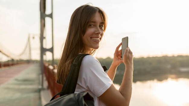 Side view of woman taking pictures of the view while traveling