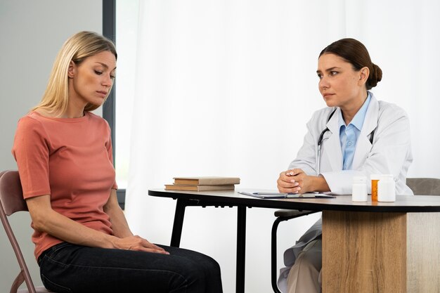 医者と話している側面図の女性