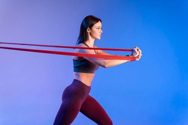 Foto gratuita addestramento della donna di vista laterale con l'elastico