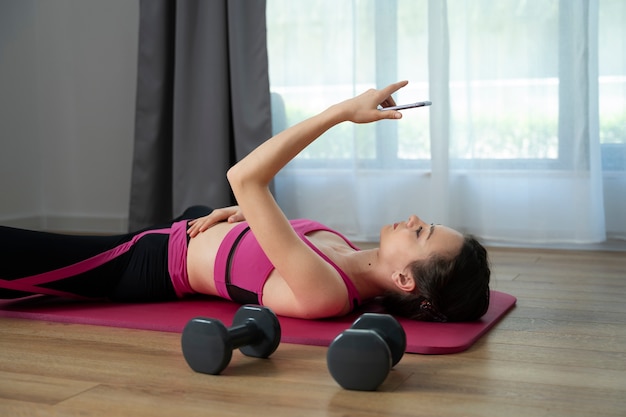 Side view woman training with smartphone