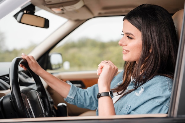 Free photo side view of woman traveling alone by car