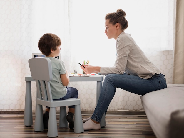 Side view of woman tutoring child at home