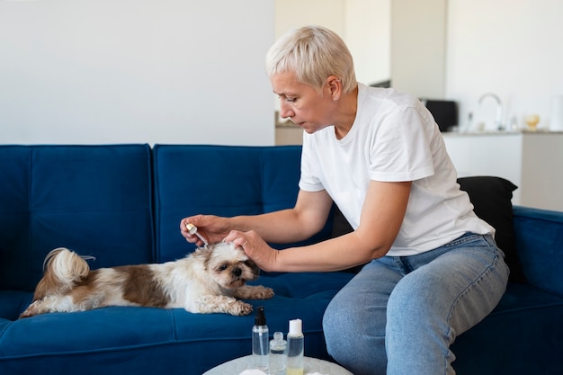 Free photo side view woman using dog serum