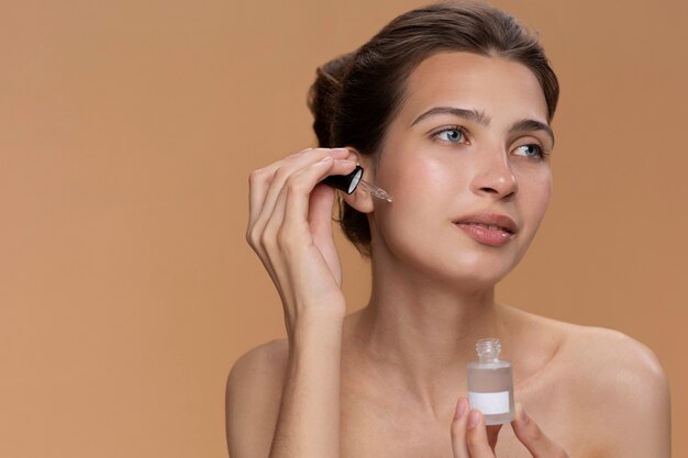 Side view woman using face serum