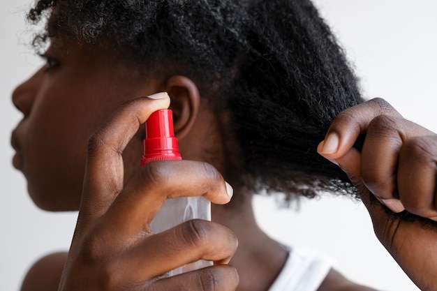 Foto gratuita donna di vista laterale che utilizza prodotto per capelli