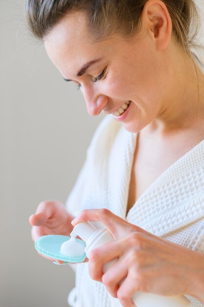 Side view of woman using lotion