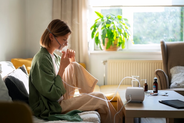 Free photo side view woman using nebulizer