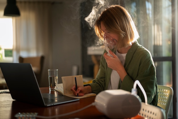 Free photo side view woman using nebulizer