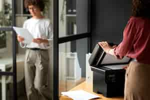 Free photo side view woman using printer