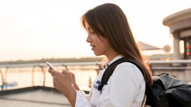 Side view of woman using smartphone while traveling alone