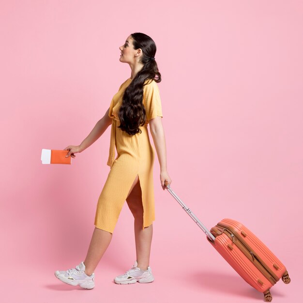 Side view woman walking while holding her baggage