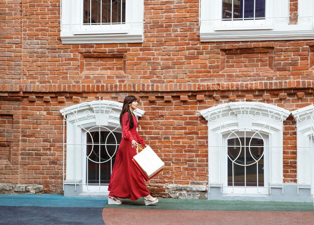 Side view of woman walking with shopping bags