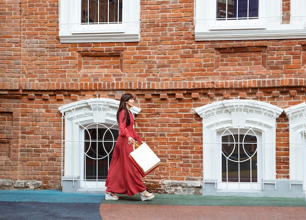 Side view of woman walking with shopping bags