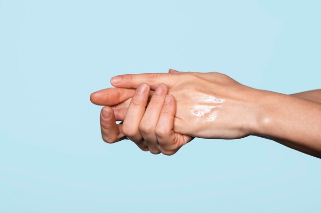 Side view woman washing hands isolated on blue