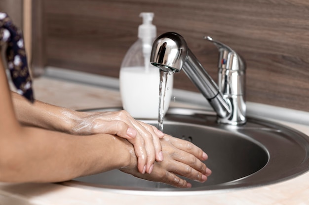 Free photo side view woman washing hands