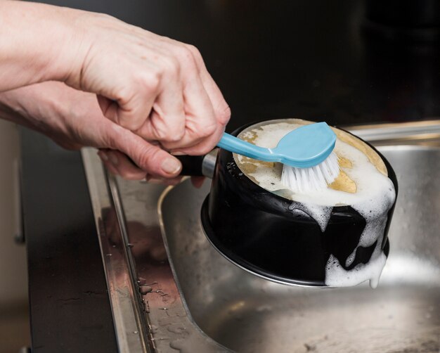 Side view of woman washing a pot