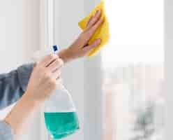 Free photo side view of woman washing window