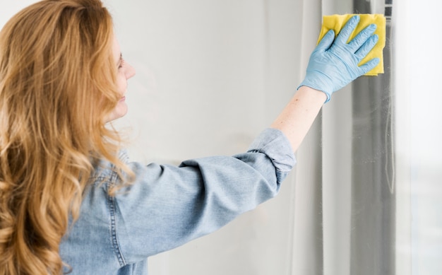 Side view of woman washing window