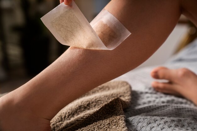 Side view woman waxing leg