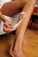 Free photo side view woman waxing leg