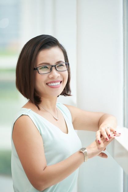 Side view of woman wearing elegant eye glasses looking at the window