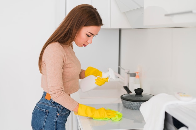 Боковой вид женщины в перчатках и уборка
