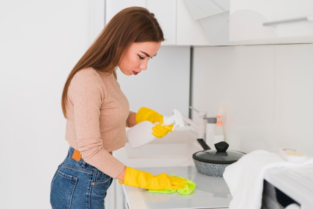 Side view woman wearing gloves and cleaning