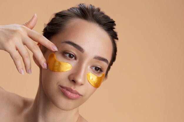 Side view woman wearing golden eye patches