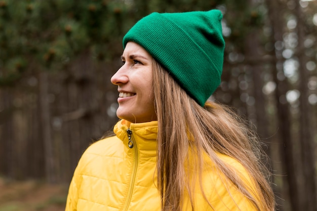 Foto gratuita donna di vista laterale che indossa un berretto verde