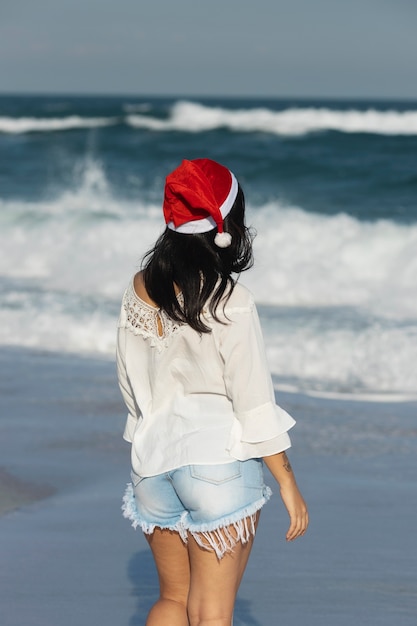 Free photo side view woman wearing santa hat