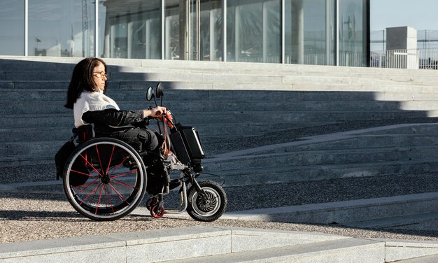 コピースペースのある通りの車椅子の女性の側面図