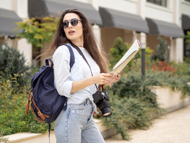 Side view woman with backpack and map