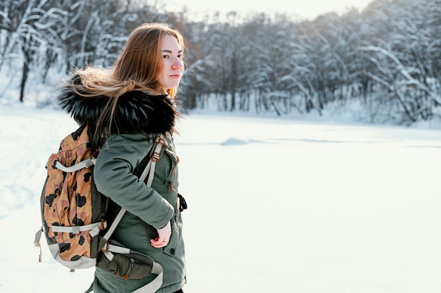 Вид сбоку женщина с рюкзаком в зимний день