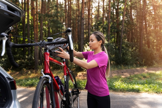 無料写真 自然の中で自転車を持つ側面図の女性