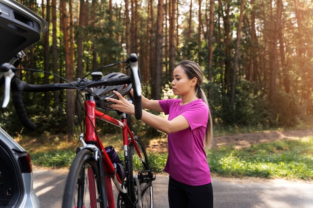 Foto gratuita donna di vista laterale con la bicicletta in natura