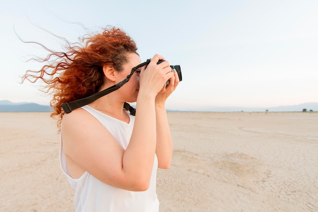 Side view woman with camera