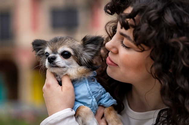 Free photo side view woman with cute chihuahua dog