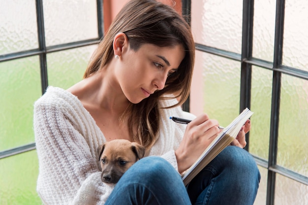 Free photo side view woman with dog and notebook